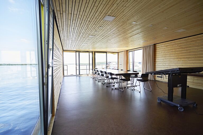 Schwimmender Seminarraum namens Boje von Innen mit Stühlen und Tischen.