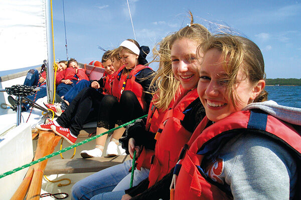 Jugendliche auf einem Segelboot auf dem See.