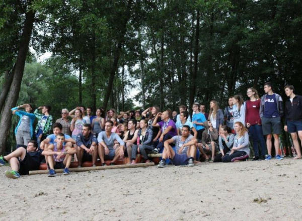 Eine Gruppe macht ein Gruppenfoto am Strand.