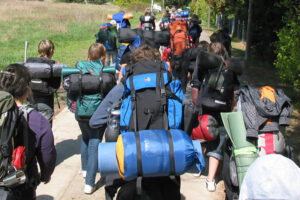 Gruppe von Jugendlichen mit großen Rucksäcken auf einer Wanderung.