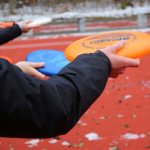 Eine Person hält eine Frisbee in der Hand.