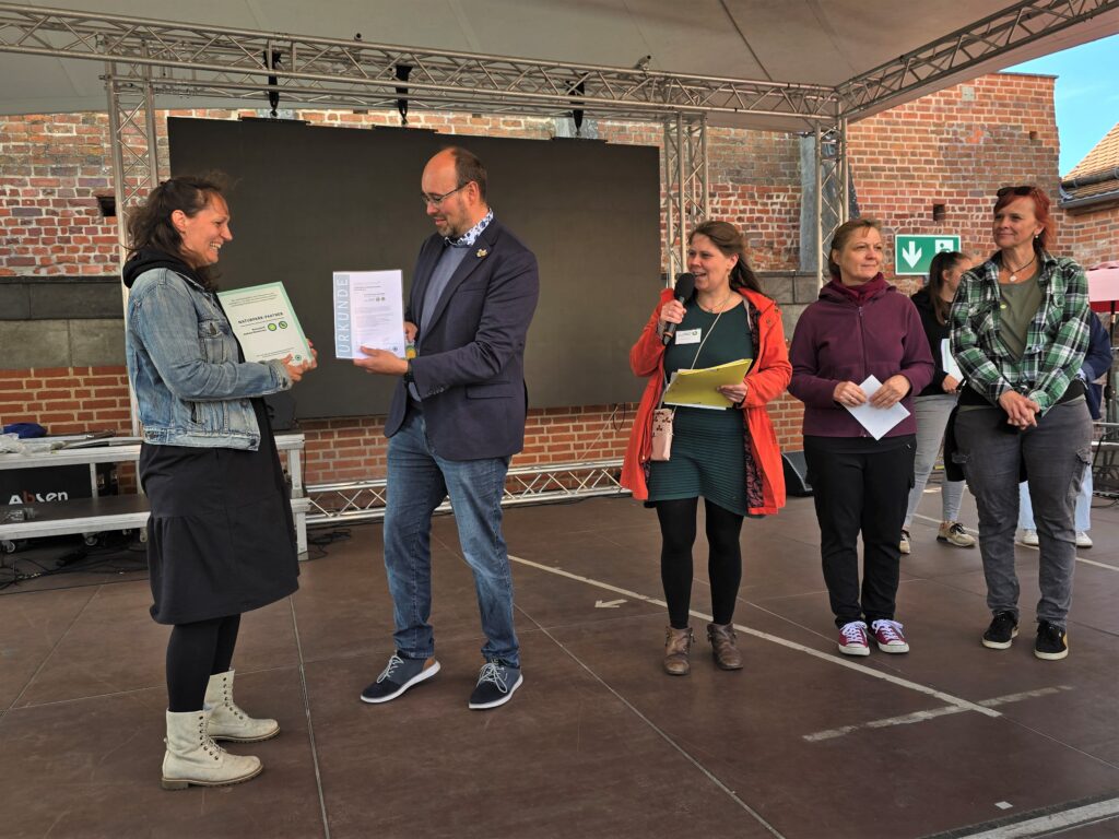 Andrea Haase (Geschäftsführung) erhält eine Urkunde.