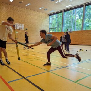 Jugendliche probieren in der Sporthalle gerade die Sportart Juggern aus.