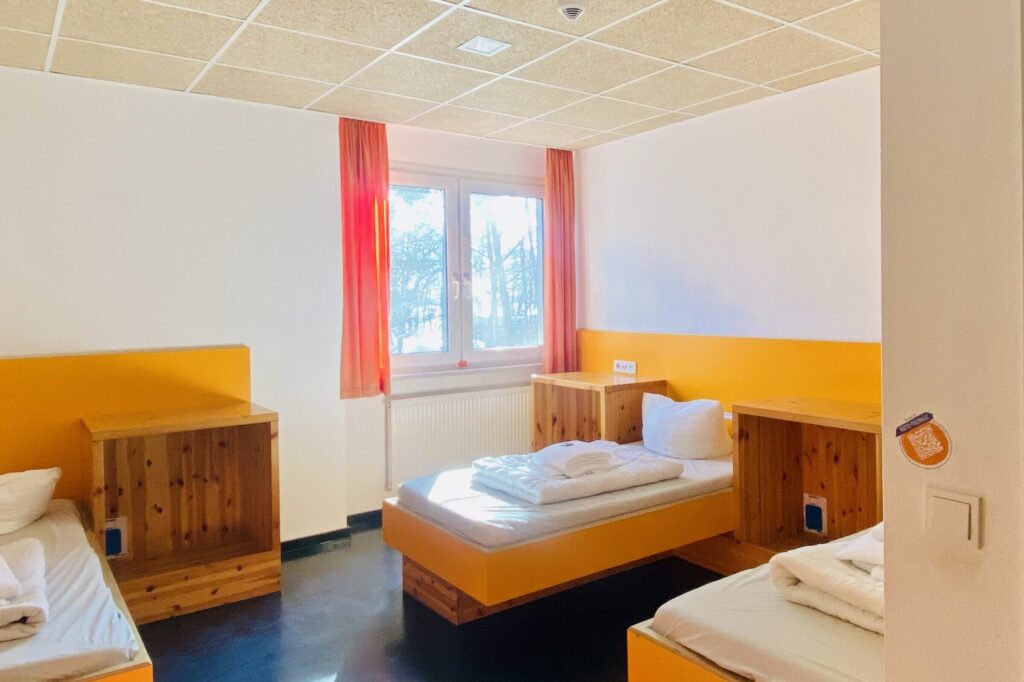 Gästehauszimmer mit drei Einzelbetten.