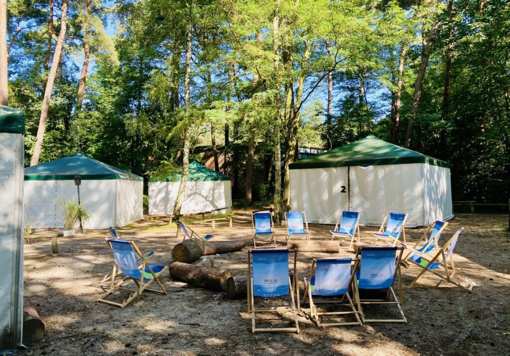 Große Zelte aufstellt um einen Feuerplatz mit Sitzmöglichkeiten im Sommer.